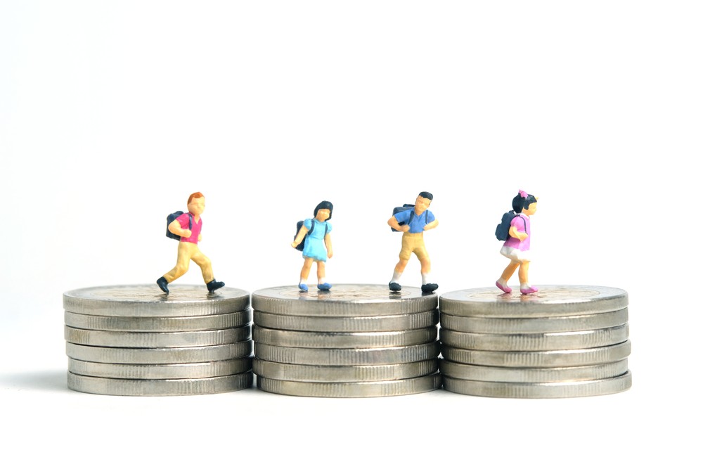 Students walking over money figuratively