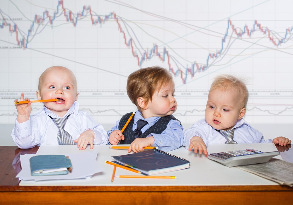 Babies dresses as businessmen do finance work