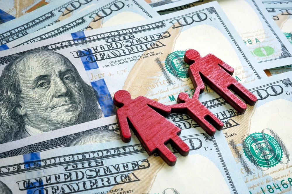 Family cutout over a pile of U.S. currency