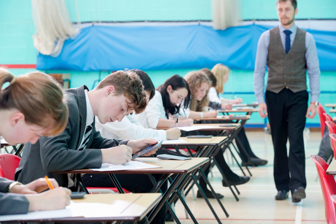Teacher supervising students taking a standardized test.